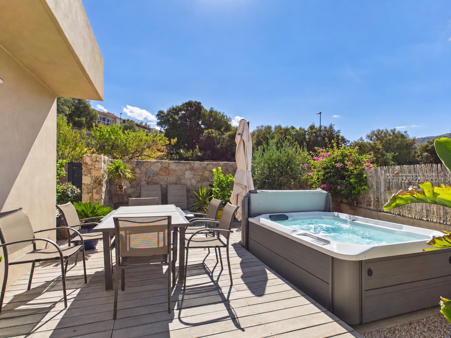Terrasse avec coin repas et spa de l'appartement à Aregno