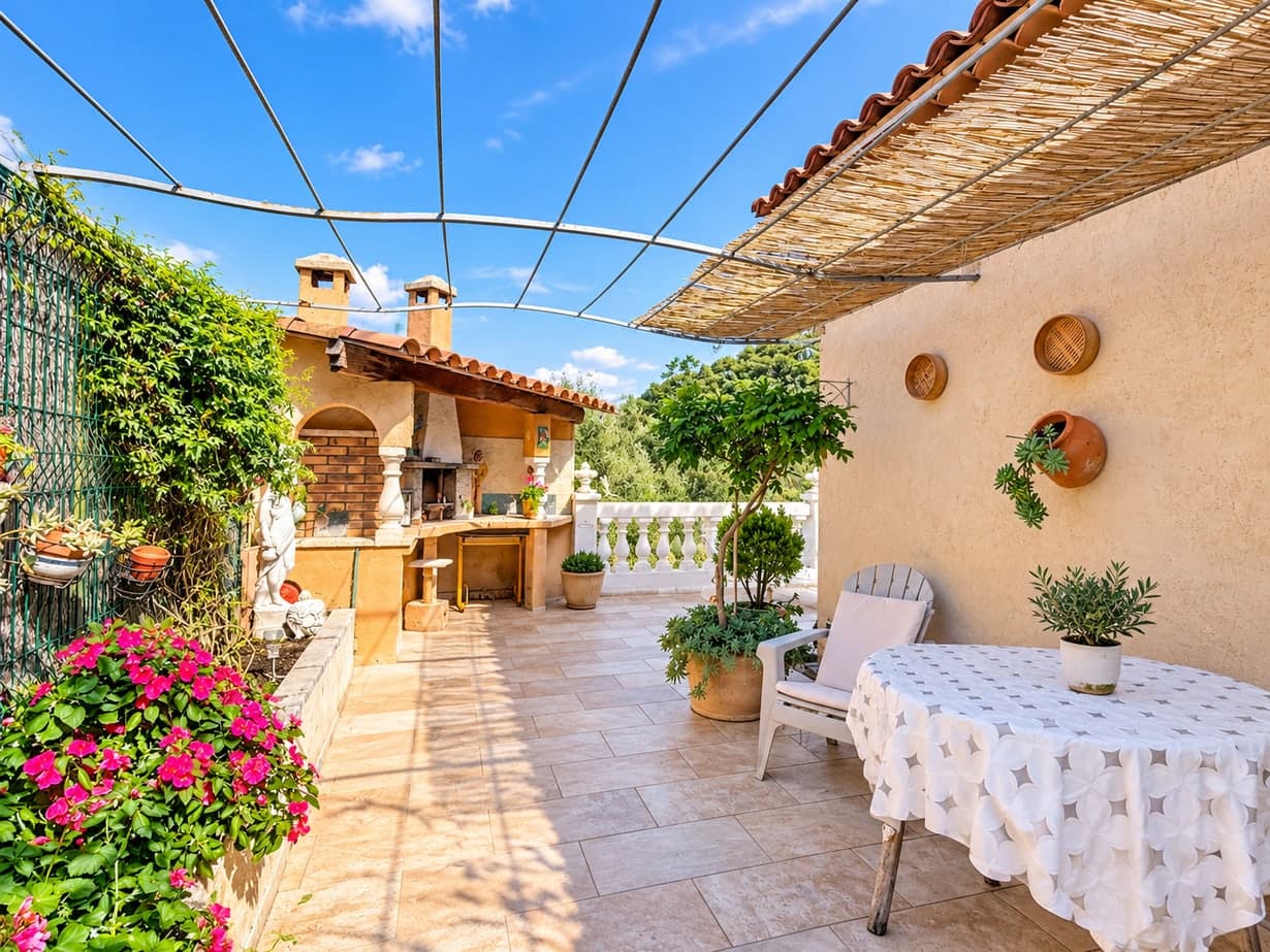 Espace repas sur la terrasse avec pergola et barbecue