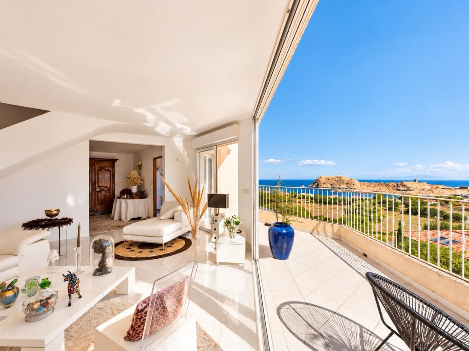 Séjour lumineux ouvert sur une terrasse face à la mer et aux îles de la Pietra